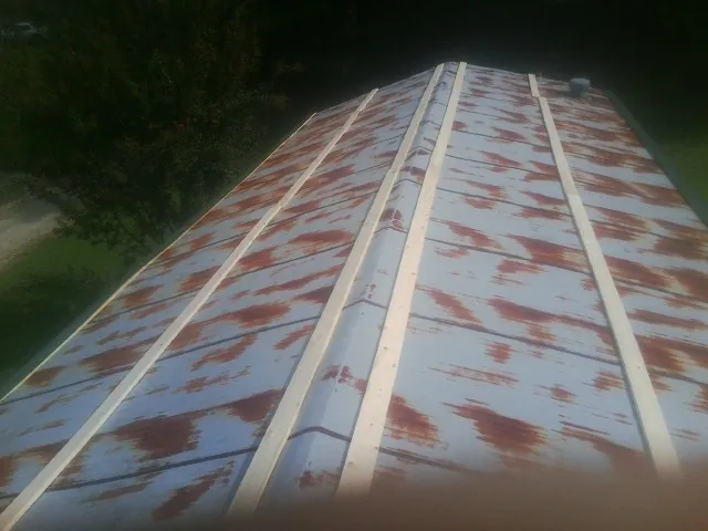 Rusted metal roof panels with new wood purlins before replacement — Storm Damage Roof Repair in Eldora by Roofing Brothers